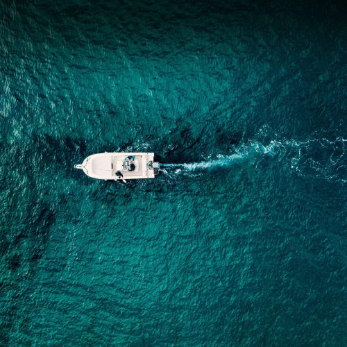 Aerial view of speed boat in motion in blue sea in Italy. Water transportation and summer leisure time activity.